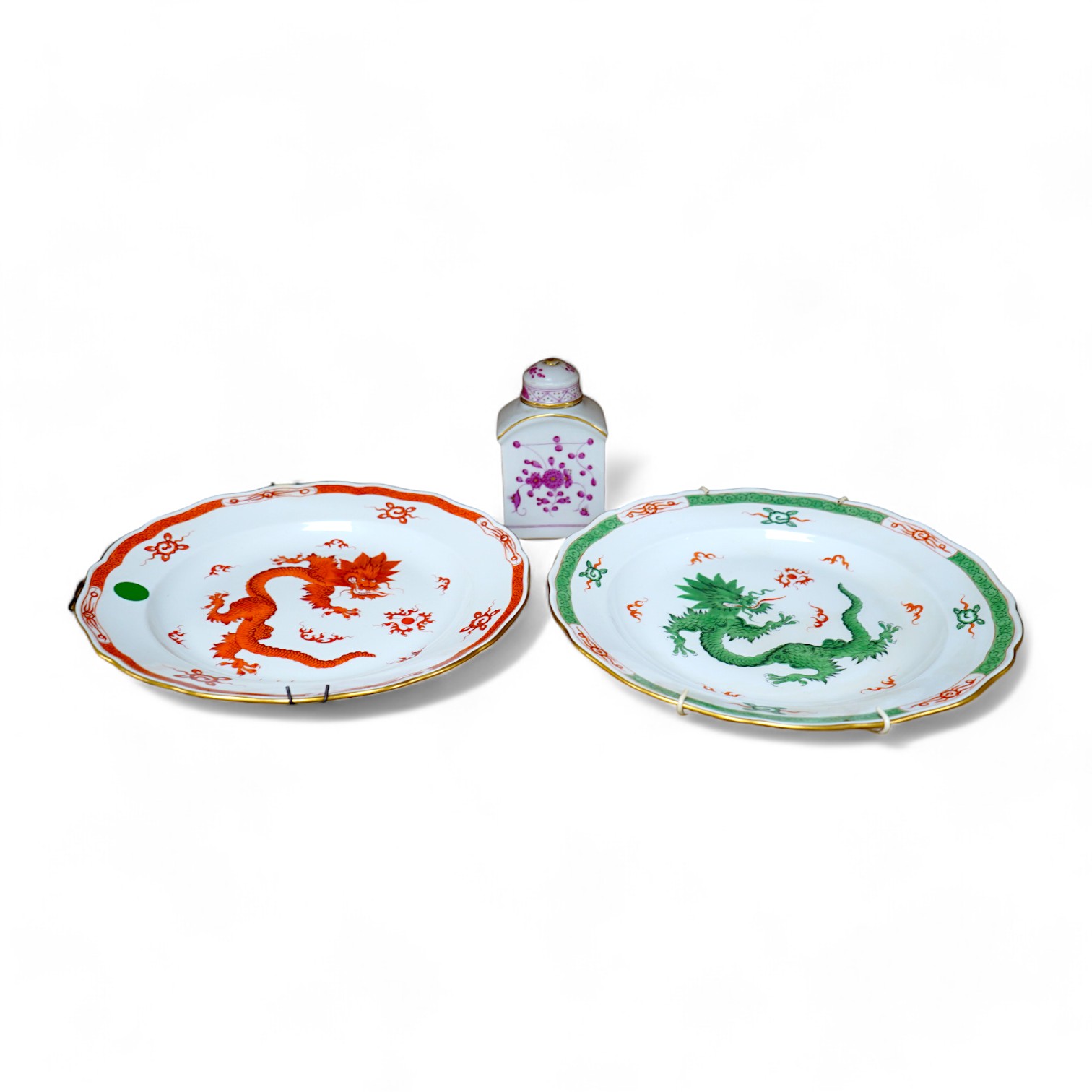 A Meissen dish, painted with a green dragon, 25.5cm diameter, another painted with an iron red dragon and a tea caddy (3). Condition - good